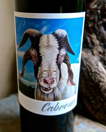 Close-up of a wine bottle label featuring a goat with glasses and a scenic background, promoting Lodi wine.