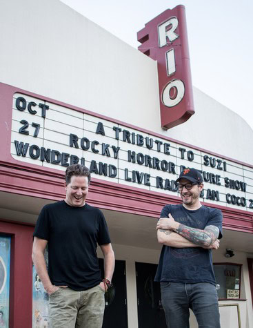 Two men standing outside RIO Theater during a music event, smiling and enjoying the occasion.