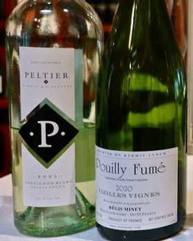 Two wine bottles from Lodi Winegrape Commission, featuring Peltier and Douilly Fumé labels, on a wooden surface.