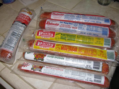 Assorted Portuguese and Hawaiian brand sausages on a kitchen counter, showcasing variety and quality for wine pairing.