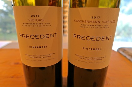 Two bottles of Zinfandel wine from Lodi Winegrape Commission, vintage 2017 and 2018, on a wooden surface.