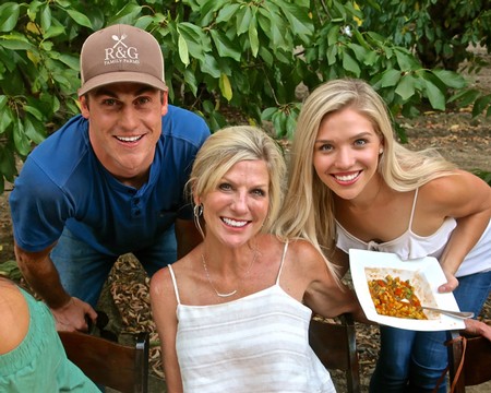 Smiling family enjoying wine and food at a Lodi vineyard, celebrating local wine culture and community.