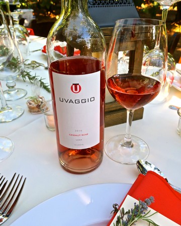 Bottle of Lodi Rosé wine on a table with a glass of rosé and elegant table setting.