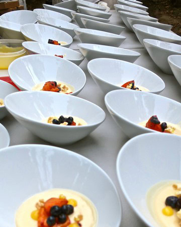 Rows of white bowls with dessert, garnished with berries and fruit, at a Lodi Winegrape Commission event.