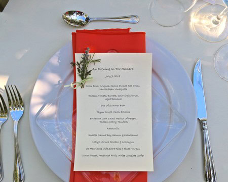 Elegant table setting with menu card, red napkin, and wine glass at Lodi Winegrape Commission event.