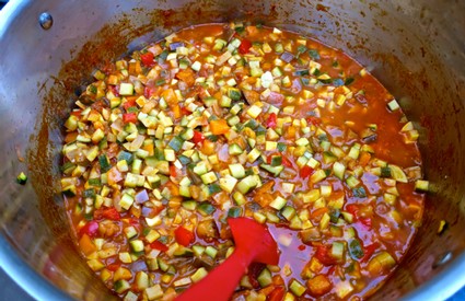 Colorful diced vegetables cooking in a pot, representing fresh ingredients for wine or food pairing.