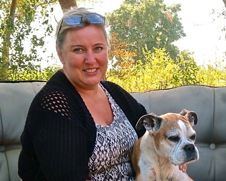 Woman smiling with her dog outdoors, representing Lodi Winegrape Commission's community engagement.