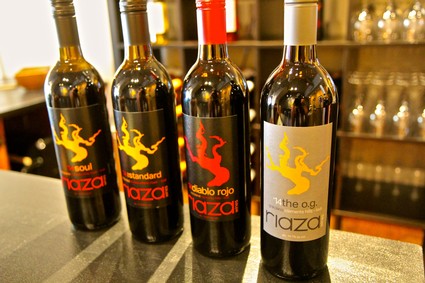Four wine bottles from Lodi Winegrape Commission with colorful labels on a bar counter.
