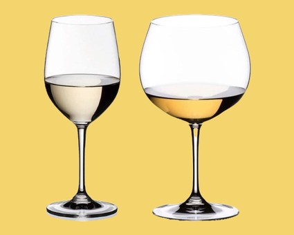 Two wine glasses, one filled with white wine and the other with red wine, on a yellow background.