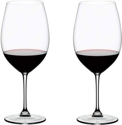 Two empty wine glasses with a small amount of red wine at the bottom, on a white background.