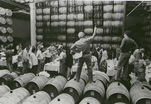 People tasting wine in a barrel room at the Lodi Winegrape Commission.