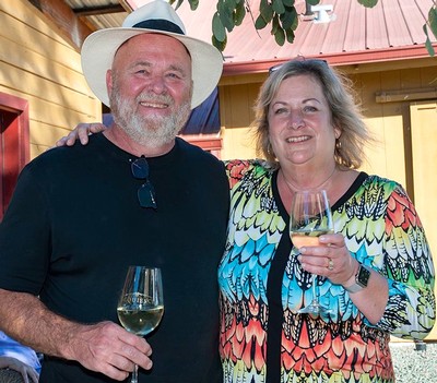 Smiling couple enjoying wine at Lodi Winegrape Commission event outdoors.