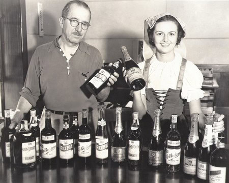 Vintage photo of a man and woman with wine bottles at Lodi Winegrape Commission event.