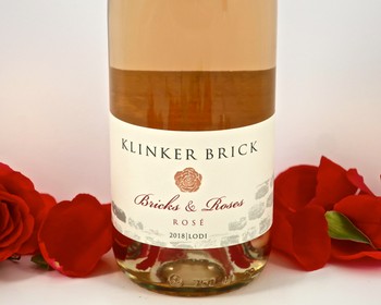 Klinker Brick Brick & Roses Rosé 2018 wine bottle with red rose petals around it.