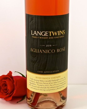 A 2018 Langetwins Aglianico Rosé wine bottle from Lodi, California, with a red rose beside it.