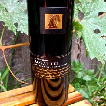 Close-up of Royal Tee wine bottle from Lodi Winegrape Commission with grapevine leaves in background.