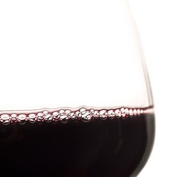 Close-up of a glass of red wine showing bubbles and rich color, representing Lodi Winegrape Commission's focus on quality win.