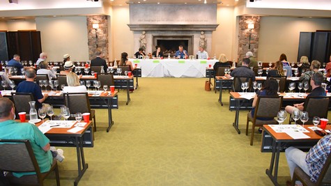 Attendees at a conference organized by the Lodi Winegrape Commission in a spacious, well-lit room with a fireplace.