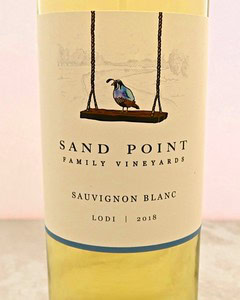 Sand Point Sauvignon Blanc 2018 wine bottle with a bird on a swing label from Lodi Winegrape Commission.