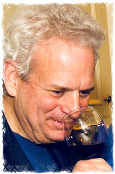 Close-up of a man smelling a glass of red wine, representing wine tasting and wine industry in Lodi, California.