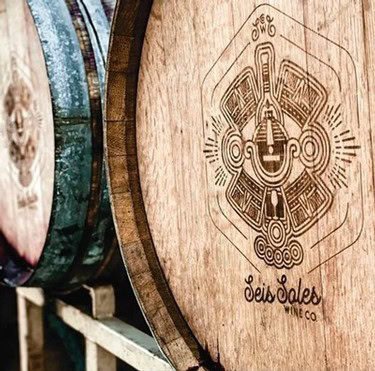 Close-up of a wooden wine barrel with intricate tribal-style engraving for Lodi Winegrape Commission.