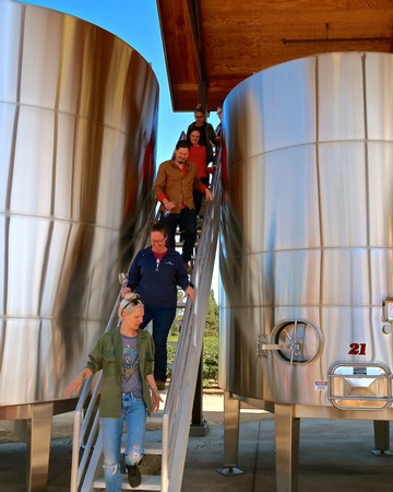 Group touring stainless steel wine tanks at a winery in Lodi, California.