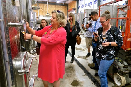 Group of people touring a winery, learning about wine production at Lodi Winegrape Commission.