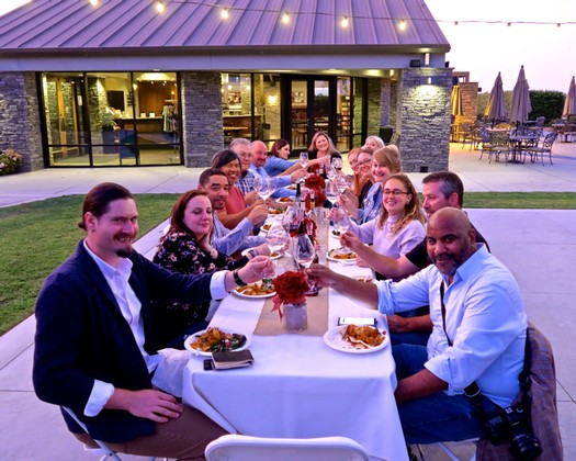 Group of people enjoying dinner outdoors at a Lodi wine event, showcasing community and wine culture.