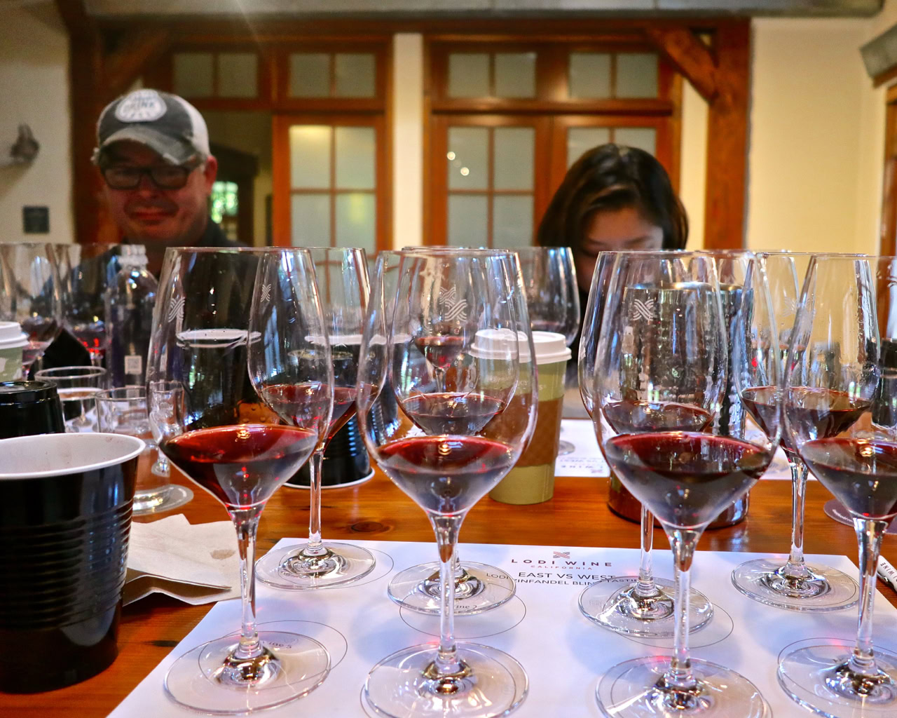 Multiple glasses of red wine on a tasting table at Lodi Winegrape Commission event.