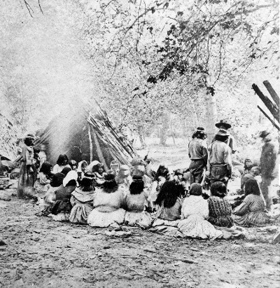 Historical black and white photo of a community gathering in Lodi wine region with people sitting and standing outdoors.