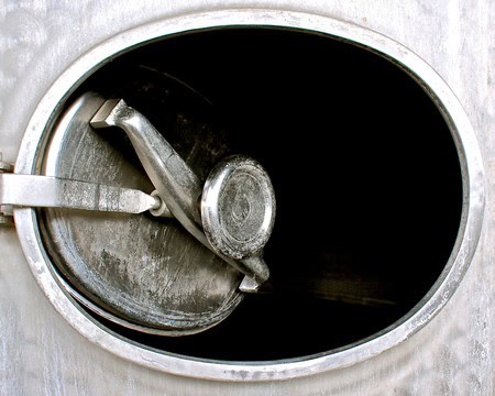 Close-up of a wine fermentation tank with a paddle agitator inside at Lodi Winegrape Commission.