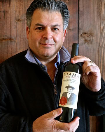 Man holding a bottle of Lodi wine, showcasing the label and emphasizing wine quality and regional origin.