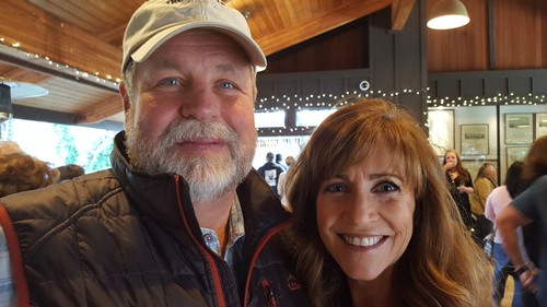Smiling man and woman at Lodi Winegrape Commission event with wine tasting and socializing.