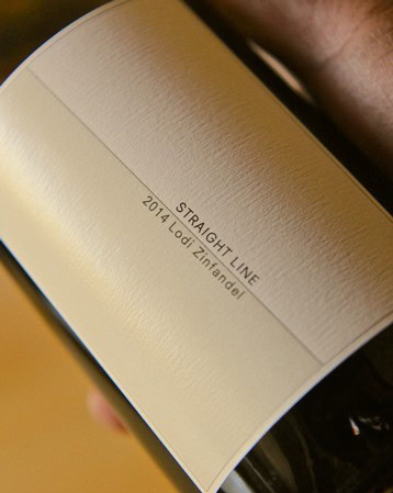 Close-up of a wine bottle label showing 'Straight Line 2014 Lodi Zinfandel' for SEO.