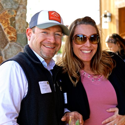 Smiling man and woman at Lodi Winegrape Commission event, enjoying wine and socializing outdoors.
