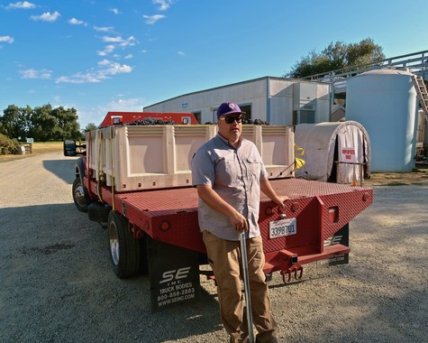 Vineyard worker standing next to a truck at Lodi Winegrape Commission in California.