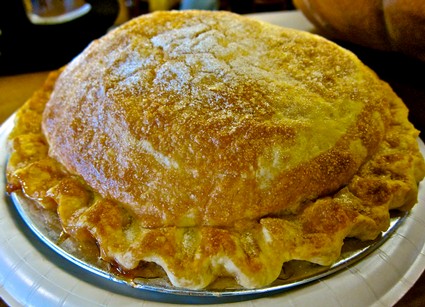 A freshly baked pie with a golden crust on a plate, representing local culinary traditions.