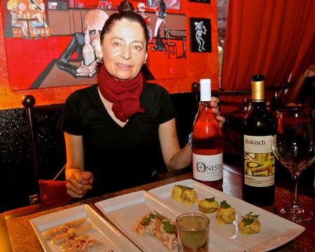 Woman enjoying wine and gourmet dishes at a restaurant, Lodi Winegrape Commission event.