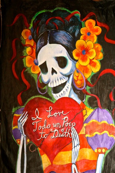 Colorful Día de los Muertos artwork featuring a skull and flowers with the message 'I Love Todo un Poco to Death'.