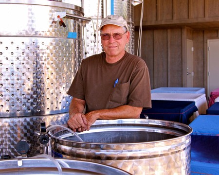 Winemaker at Lodi Winegrape Commission with stainless steel fermentation tanks.
