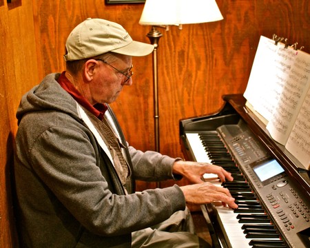 Man playing digital piano at Lodi Winegrape Commission event in a cozy indoor setting.