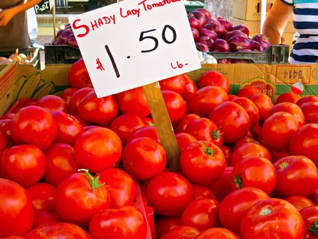 Bright red lady tomatoes for sale at Lodi Winegrape Commission market, priced at $1.50 per pound.