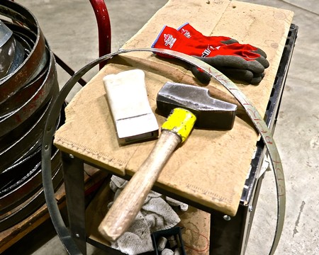 Tools and equipment used in wine production, including gloves, hammer, and cleaning supplies.