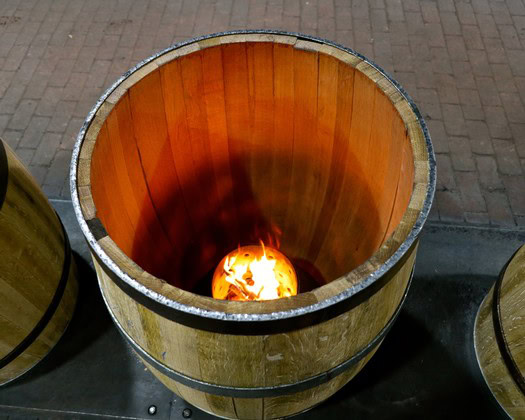 Wooden wine barrel with glowing glass orb inside at Lodi Winegrape Commission event.
