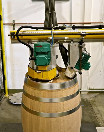 Industrial wine processing equipment mounted on a wine barrel for grape fermentation or storage.