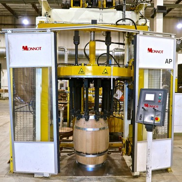 Automated wine barrel filling machine at a winery, used for filling barrels with wine efficiently.