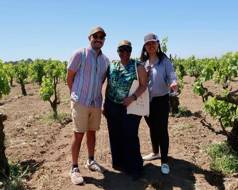 Group of three people enjoying a vineyard tour at Lodi Winegrape Commission in sunny weather.