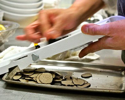 Close-up of hands slicing truffles at a Lodi wine and food tasting event.