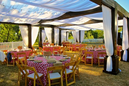 Outdoor event setup with tables, chairs, and canopy at Lodi Winegrape Commission.