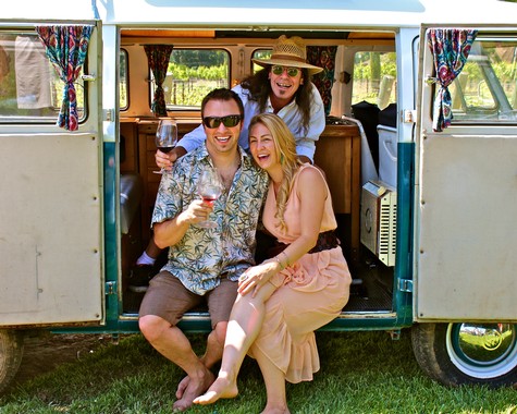 Group of friends enjoying wine and laughter at a Lodi Winegrape Commission event in a vintage van.